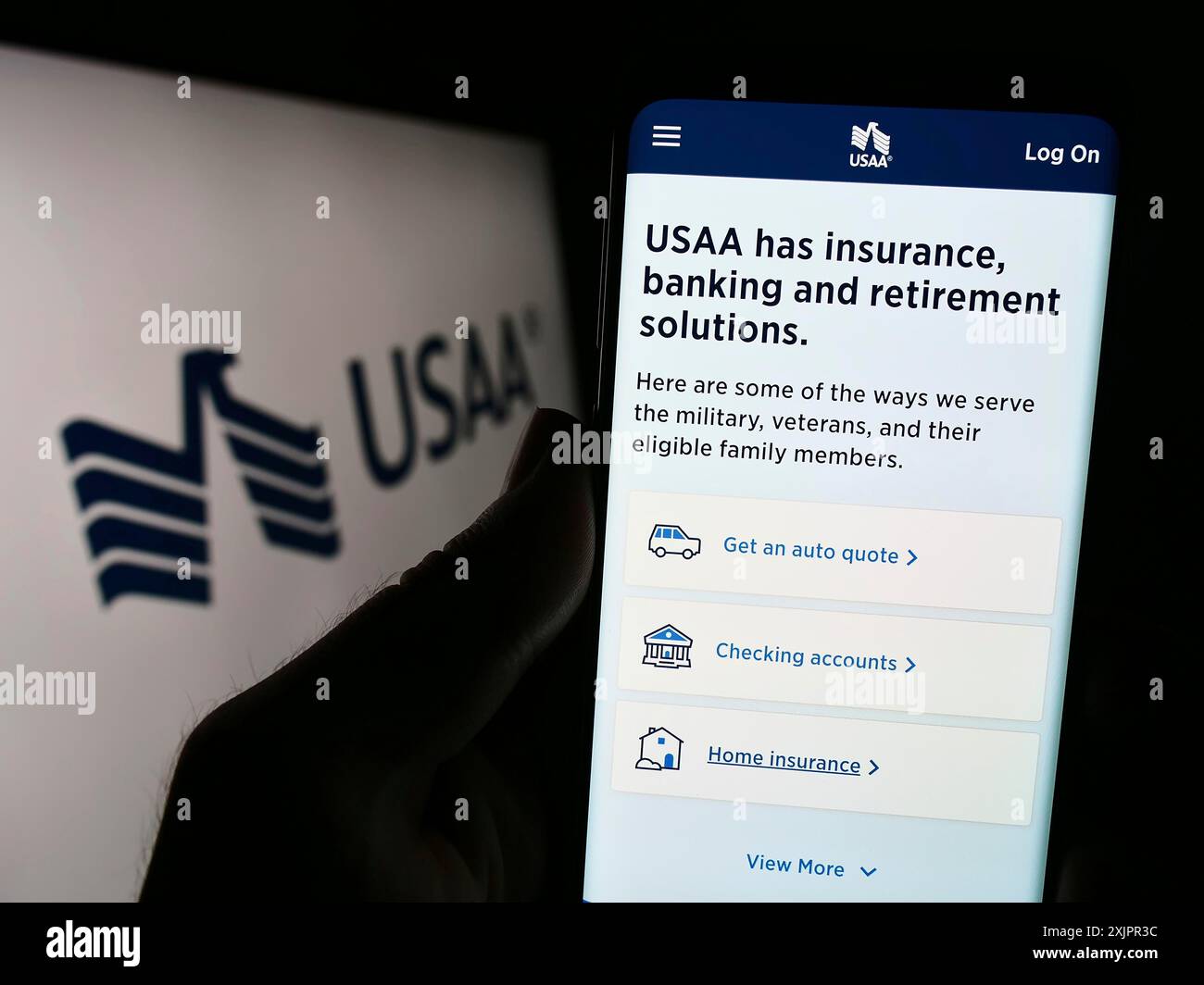 Stoccarda, Germania, 08-20-2023: Persona che tiene il cellulare con la pagina web della United Services Automobile Association (USAA) sullo schermo davanti al logo. Foto Stock
