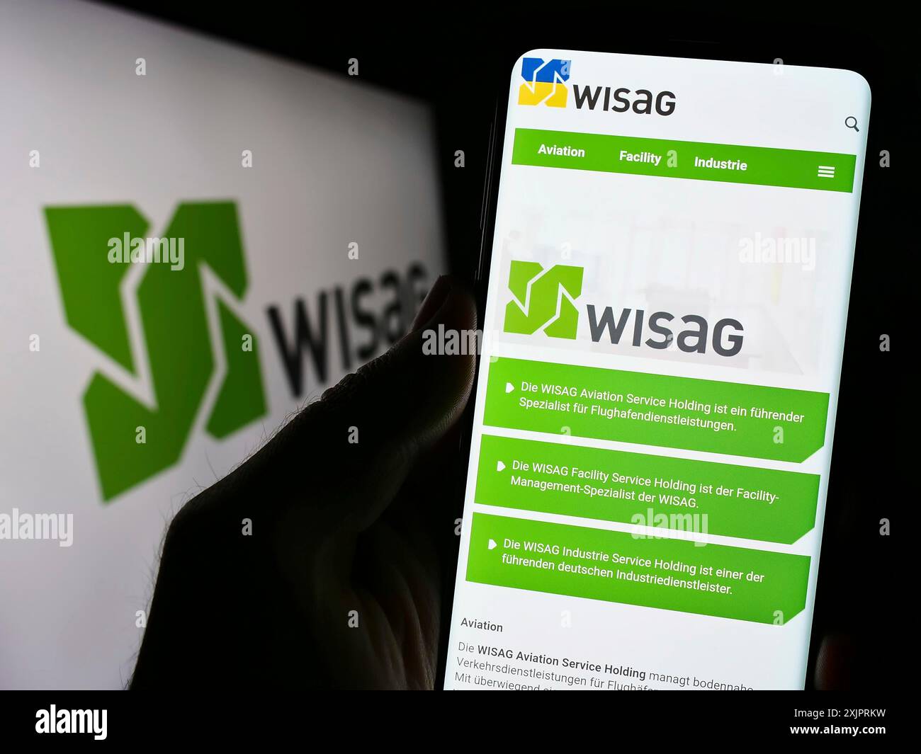 Stoccarda, Germania, 08-28-2023: Persona che detiene il cellulare con pagina web della società tedesca WISAG Dienstleistungsholding se su schermo con logo. Concentrati su Foto Stock