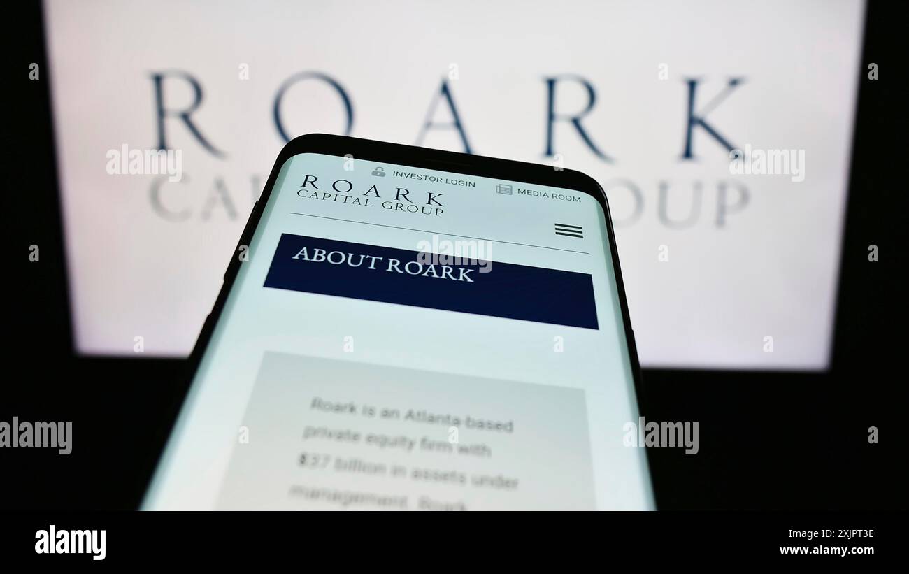 Stoccarda, Germania, 09-02-2023: Telefono cellulare con pagina web della società statunitense Roark Capital Management LLC sullo schermo davanti al logo aziendale. Concentrati su Foto Stock