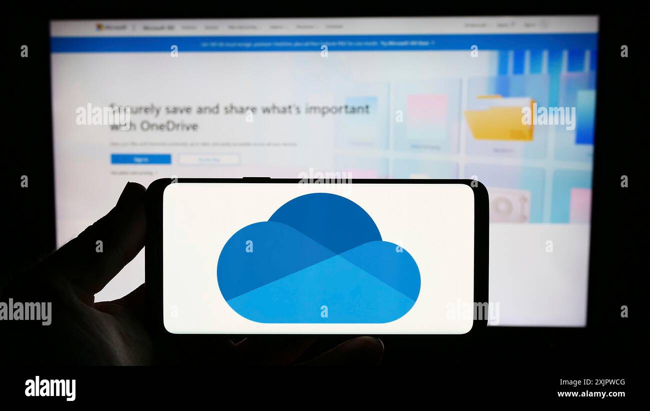 Stoccarda, Germania, 09-21-2023: Persona che possiede uno smartphone con logo del servizio di hosting di file Microsoft OneDrive sullo schermo davanti al sito Web. Concentrati Foto Stock