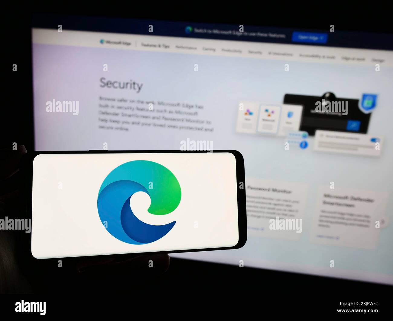 Stoccarda, Germania, 09-21-2023: Persona con smartphone con logo del browser Web Microsoft Edge sullo schermo davanti al sito Web. Concentrati sul telefono Foto Stock