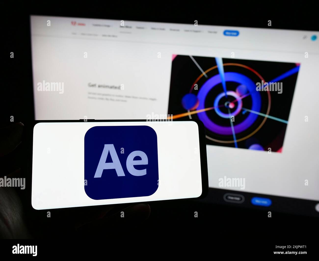 Stoccarda, Germania, 09-23-2023: Persona che tiene il cellulare con il logo del software di grafica animata Adobe After Effects sullo schermo davanti alla pagina web. Foto Stock