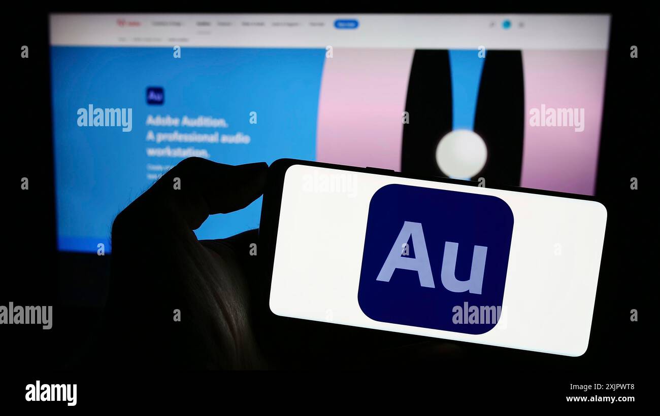 Stoccarda, Germania, 09-23-2023: Persona che tiene in mano il cellphoen con il logo della stazione audio digitale Adobe Audition sullo schermo di fronte all'azienda Foto Stock
