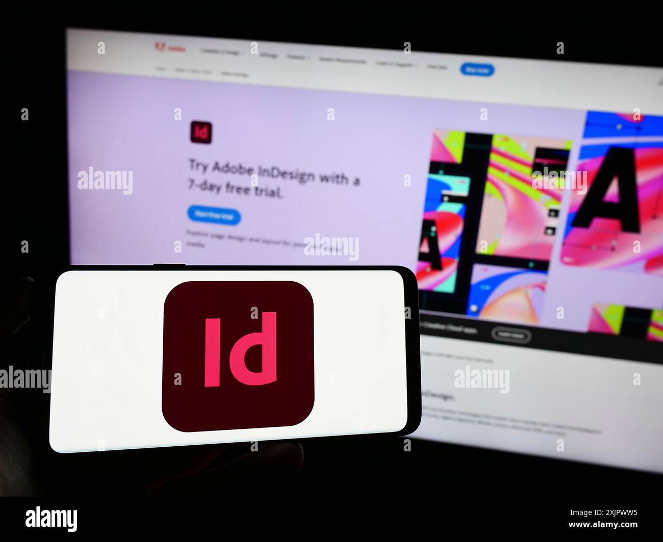 Stoccarda, Germania, 09-23-2023: Persona che tiene un cellulare con il logo del software di desktop publishing Adobe InDesign sullo schermo davanti all'azienda Foto Stock