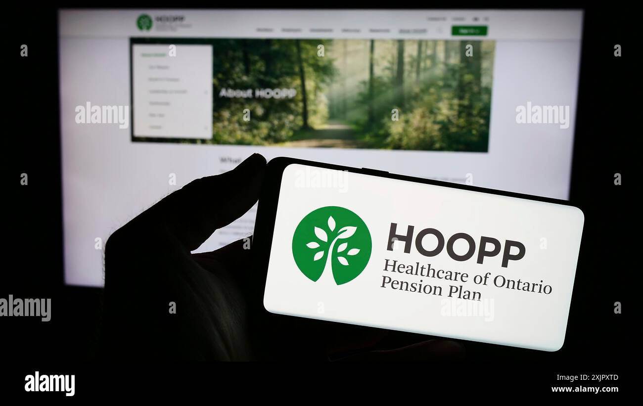 Stoccarda, Germania, 10-16-2023: Persona con smartphone con logo di Healthcare of Ontario Pension Plan (HOOPP) davanti al sito web. Concentrati sul telefono Foto Stock
