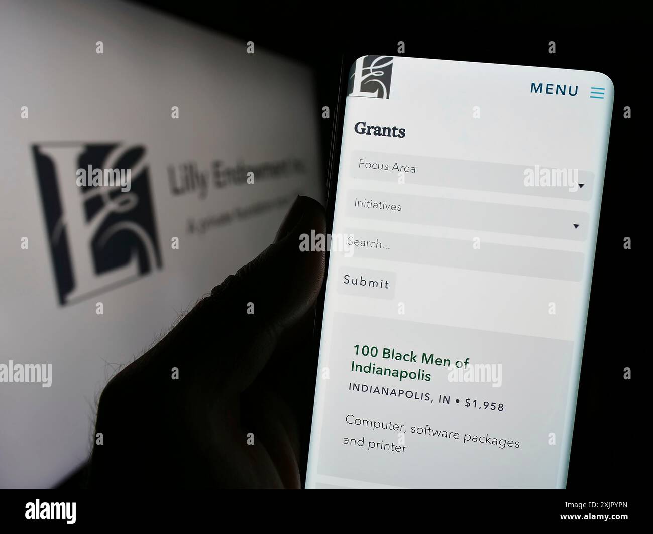 Stuttgart, Germania, 11-02-2023: Persona che possiede uno smartphone con sito web della fondazione statunitense Lilly Endowment Inc. Davanti al logo. Concentrati sul centro di Foto Stock