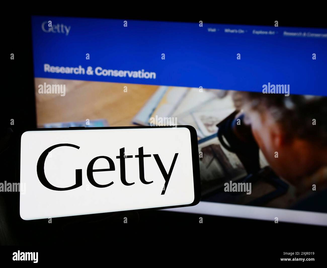 Stuttgart, Germania, 11-03-2023: Persona che tiene un telefono cellulare con il logo della fondazione artistica americana J. Paul Getty Trust davanti alla pagina web. Concentrati su Foto Stock
