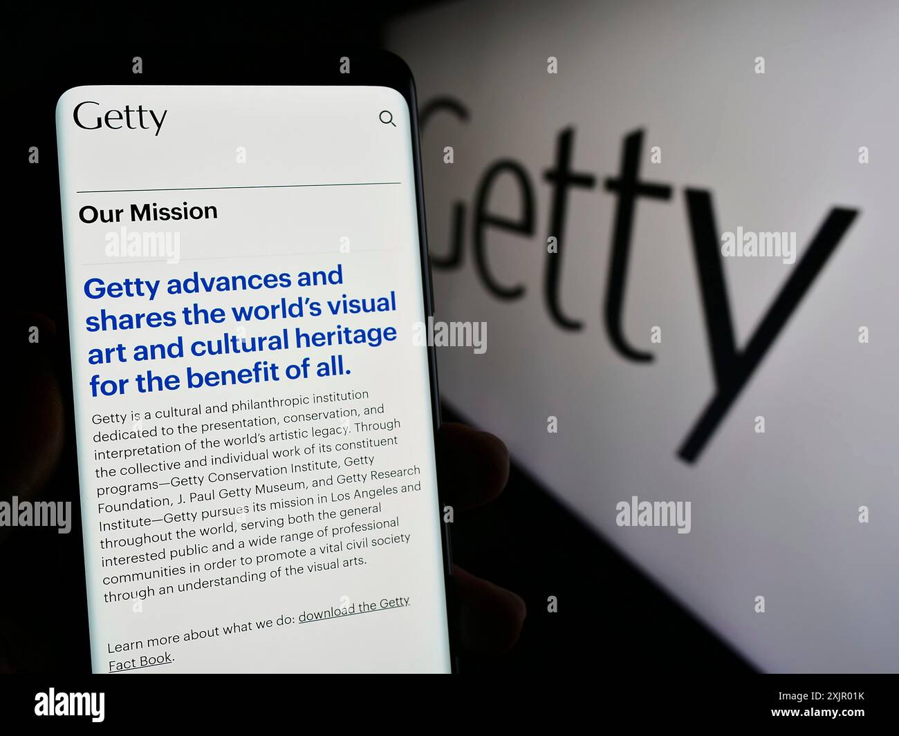 Stoccarda, Germania, 11-03-2023: Persona che tiene il cellulare con pagina web della fondazione artistica americana J. Paul Getty Trust davanti al logo. Concentrati sul centro di Foto Stock