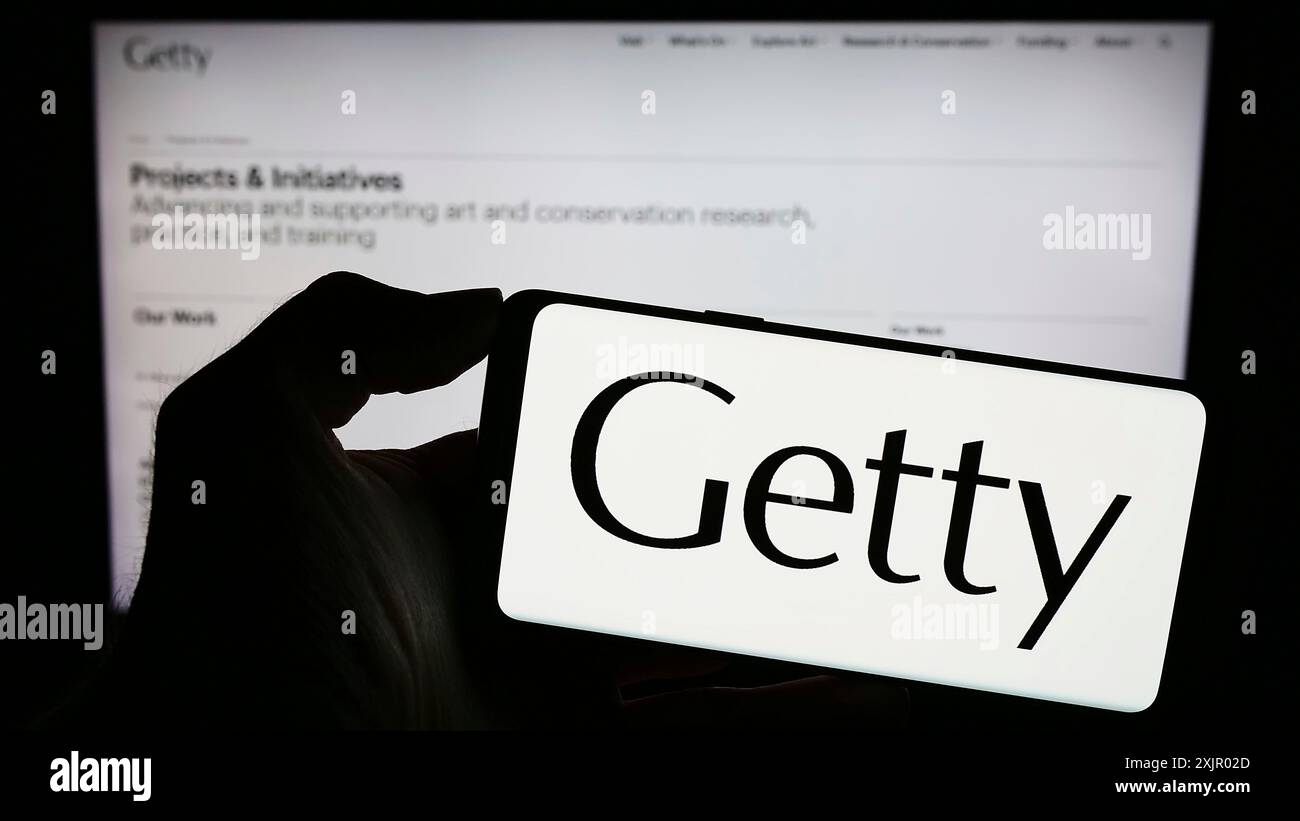Stoccarda, Germania, 11-03-2023: Persona che tiene il cellulare con il logo della fondazione artistica americana J. Paul Getty Trust davanti alla pagina web. Concentrati sul telefono Foto Stock