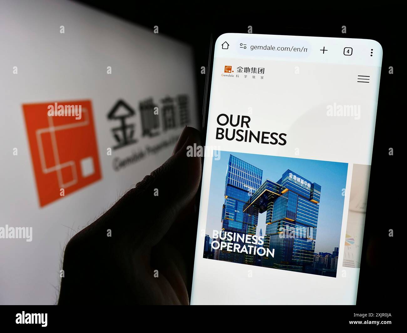 Stoccarda, Germania, 11-10-2023: Persona che possiede uno smartphone con sito web di Gemdale Properties and Investment Corporation Limited con logo. Concentrati su Foto Stock