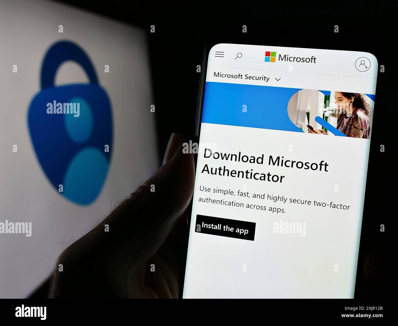 Stoccarda, Germania, 11-14-2023: Persona che detiene un cellulare con pagina web dell'app di autenticazione Microsoft Authenticator davanti al logo aziendale. Concentrati Foto Stock