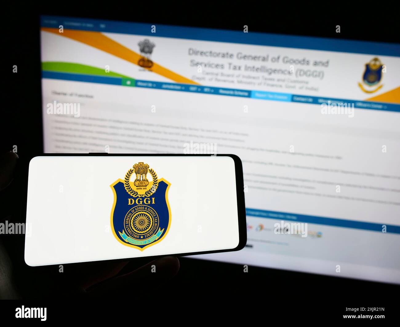 Stoccarda, Germania, 11-28-2023: Persona che detiene un telefono cellulare con il logo della direzione generale indiana dell'intelligence GST (DGGI) di fronte alla pagina web. Foto Stock