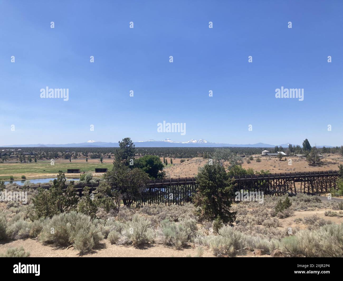 Vista su un ponte di cavalletti al Brasada Ranch, un resort di lusso vicino a Bend, verso le montagne Sisters in Oregon. Foto Stock