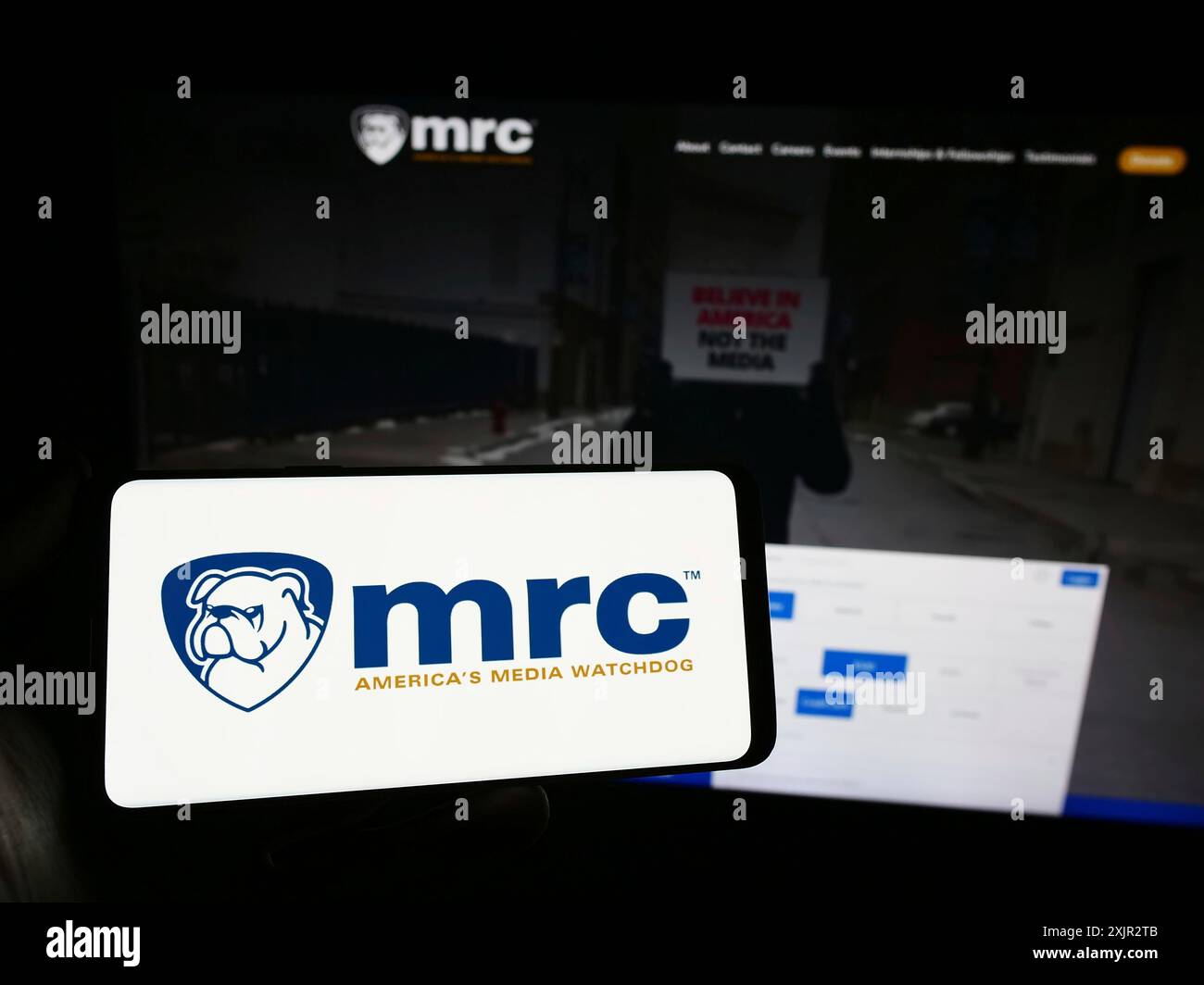 Stoccarda, Germania, 12-14-2023: Persona con smartphone e logo dell'organizzazione di controllo Media Research Center (MRC) davanti al sito web. Concentrati Foto Stock