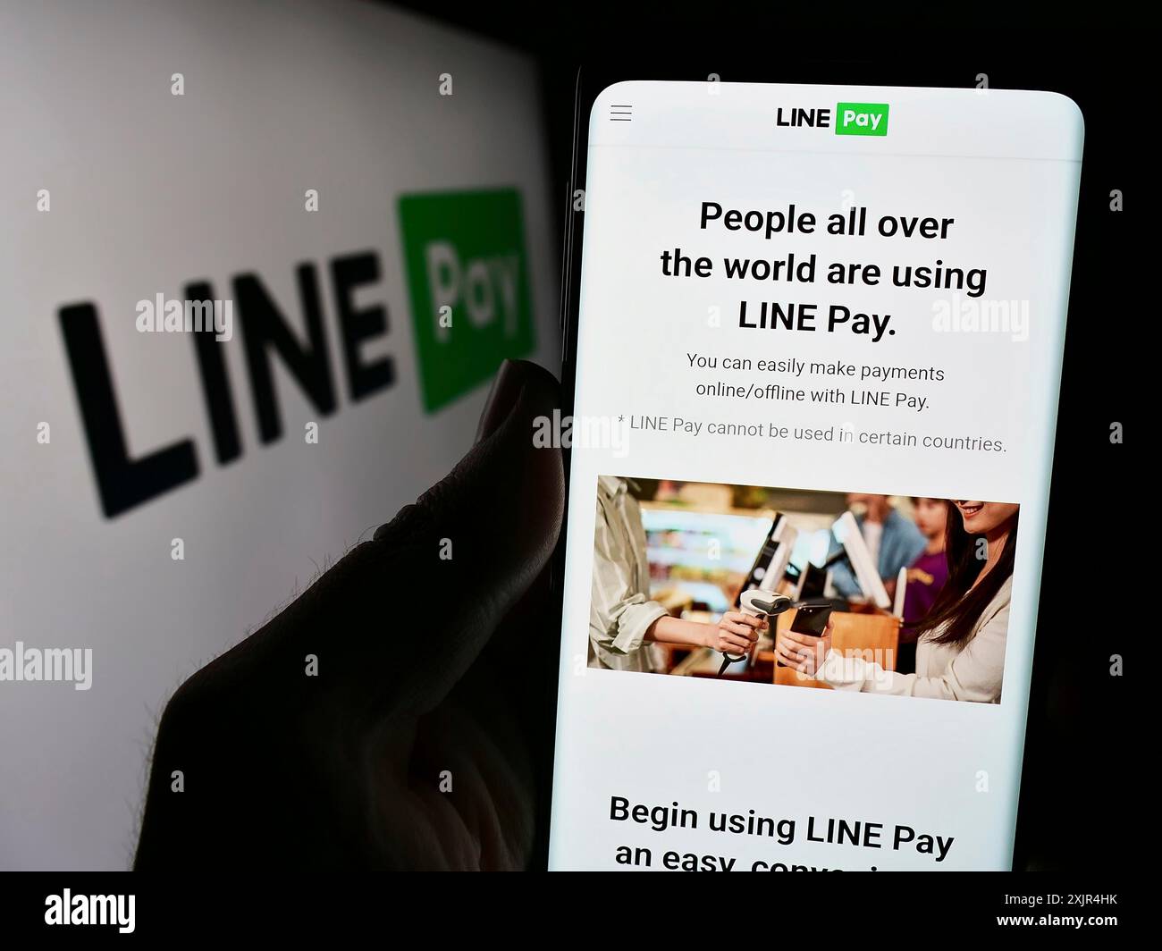 Stoccarda, Germania, 02-11-2024: Persona che detiene il cellulare con pagina web della società thailandese di pagamento LINE pay davanti al logo aziendale. Concentrati sul centro di Foto Stock