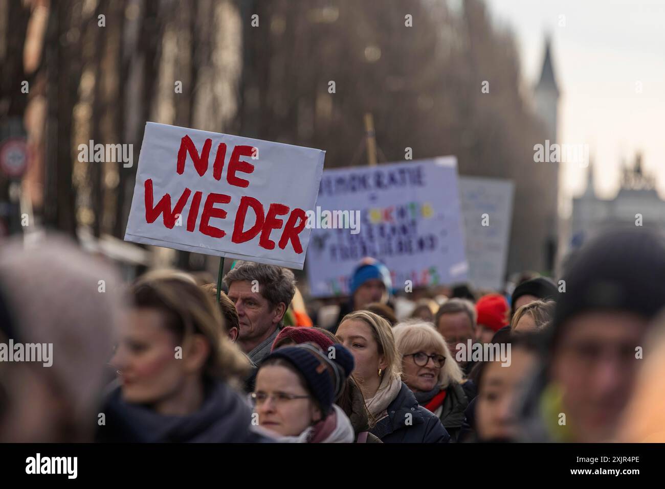Persone che hanno i segni di una manifestazione a Monaco. Questo dice: Mai più Foto Stock