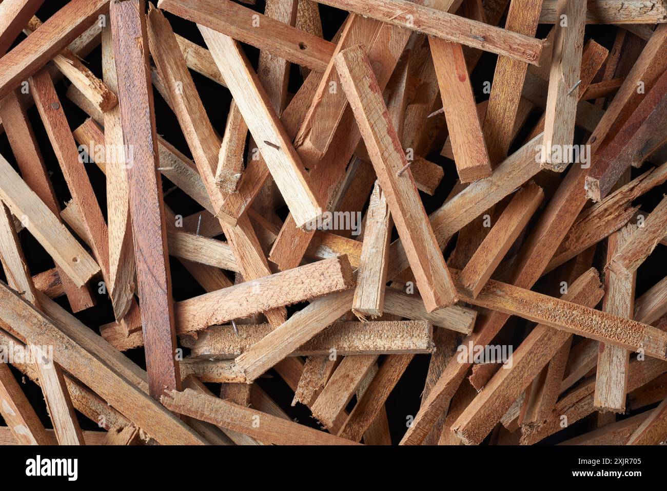 cumulo di pezzi di legno raschiati con chiodi sporgenti, lasciati da progetti di costruzione o demolizione, rischio di lesioni e concetto di sicurezza Foto Stock