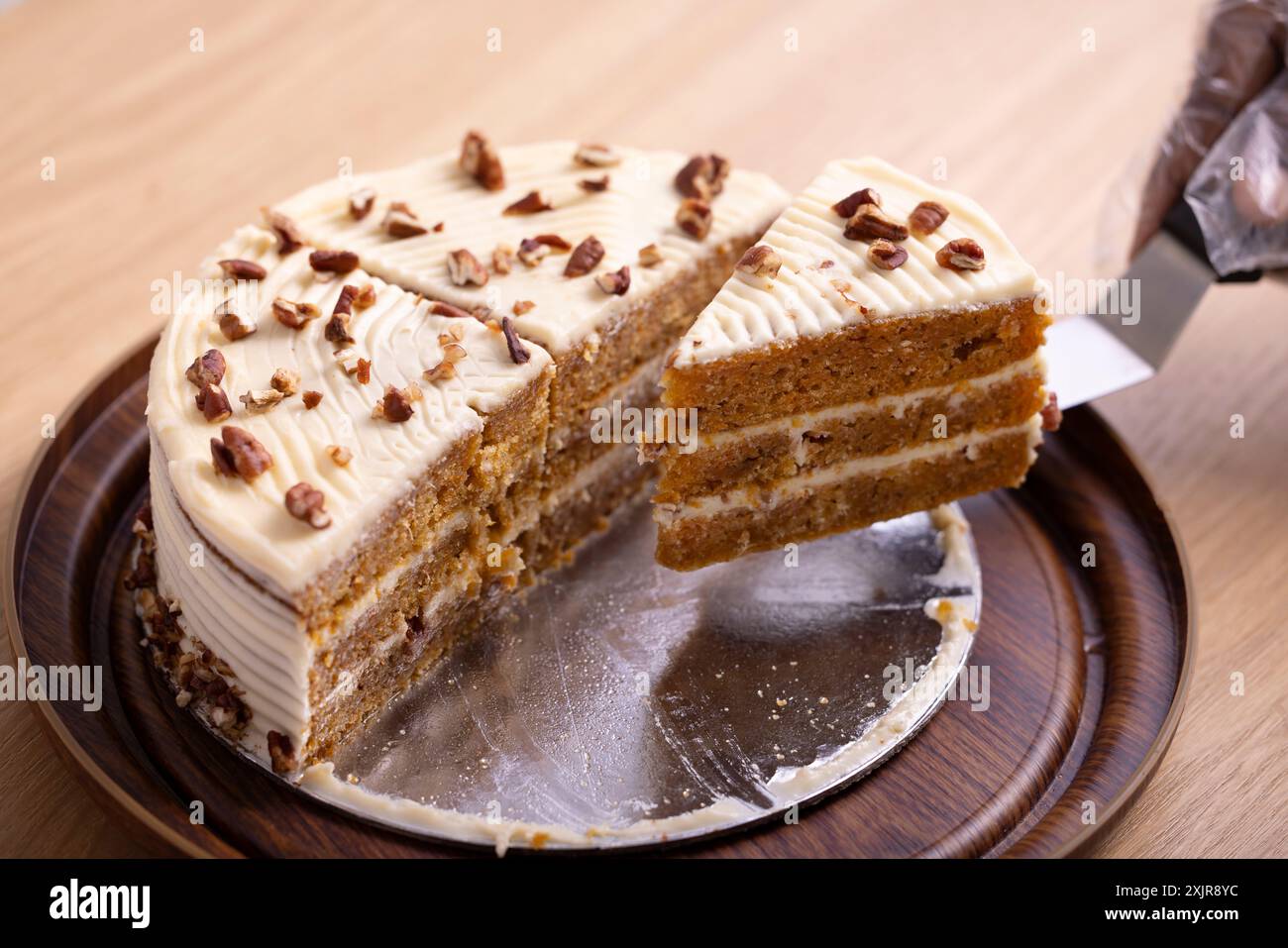 Deliziosa fetta di torta alla carota con glassa al formaggio. Un succulento primo piano di una fetta di torta di carote con ricca glassa di formaggio spalmabile. Foto Stock