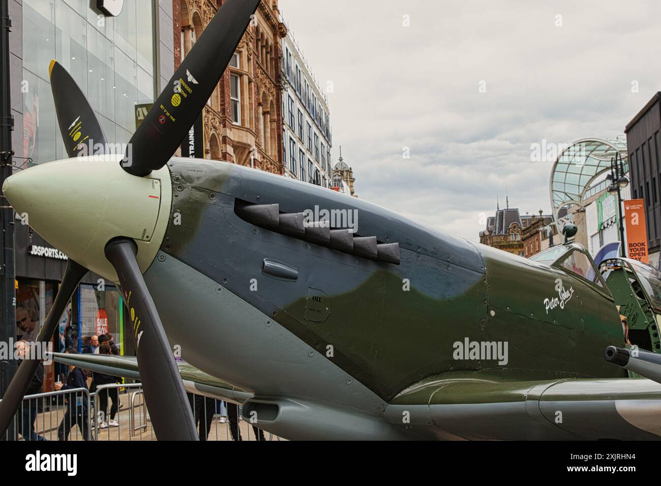 Vista ravvicinata di un aereo militare d'epoca, in particolare di un aereo da caccia dell'epoca della seconda guerra mondiale, esposto all'aperto in un'area urbana. L'aereo ha un Foto Stock