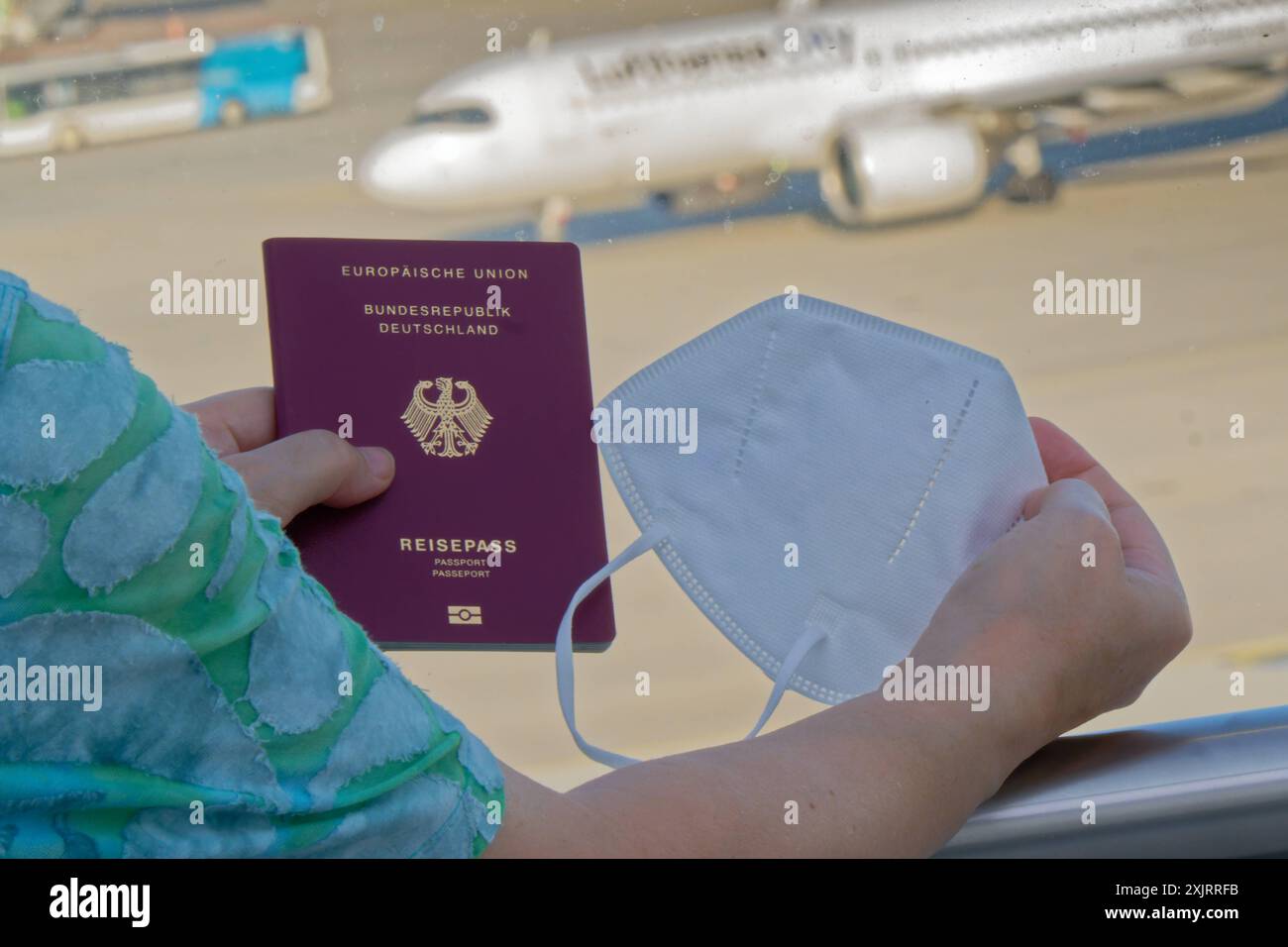 Die Corona-Fälle steigen an. MIT Reisepass und FFP2- Atemschutzmaske am Flughafen München. München Bayern Deutschland *** Corona casi in aumento con passaporto e respiratore FFP2 presso l'aeroporto di Monaco Monaco Baviera Germania Copyright: XRolfxPossx Foto Stock