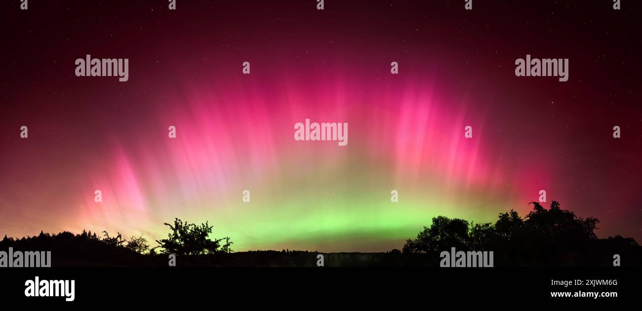 Affascinante aurora boreale sull'Europa centrale. Vibrante Aurora Boreale a forma di arco rosa e verde nel cielo notturno della Germania Foto Stock