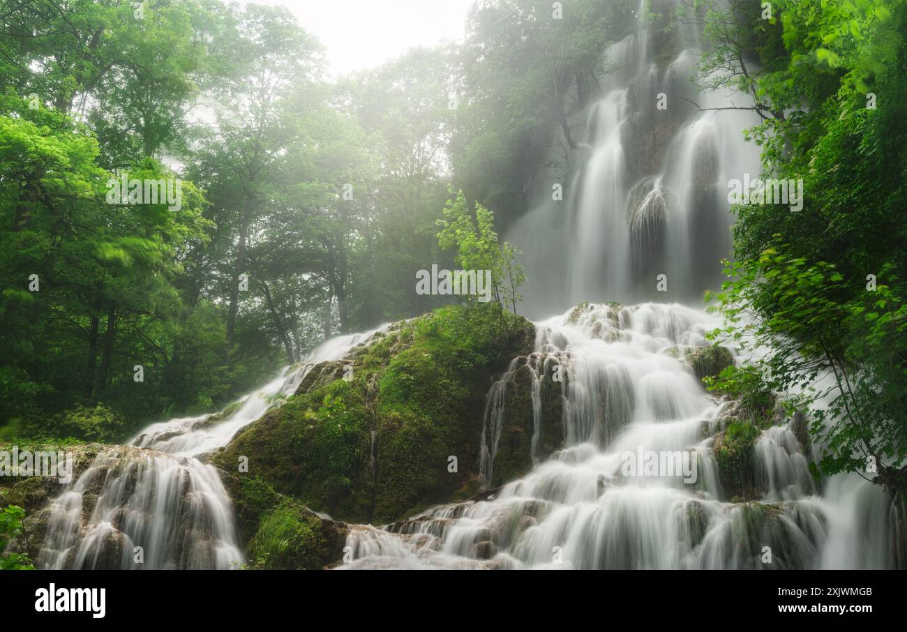 Splendide cascate circondate da una lussureggiante vegetazione. Tranquillo ma potente scatto naturale delle cascate di Bad Urach in Germania Foto Stock