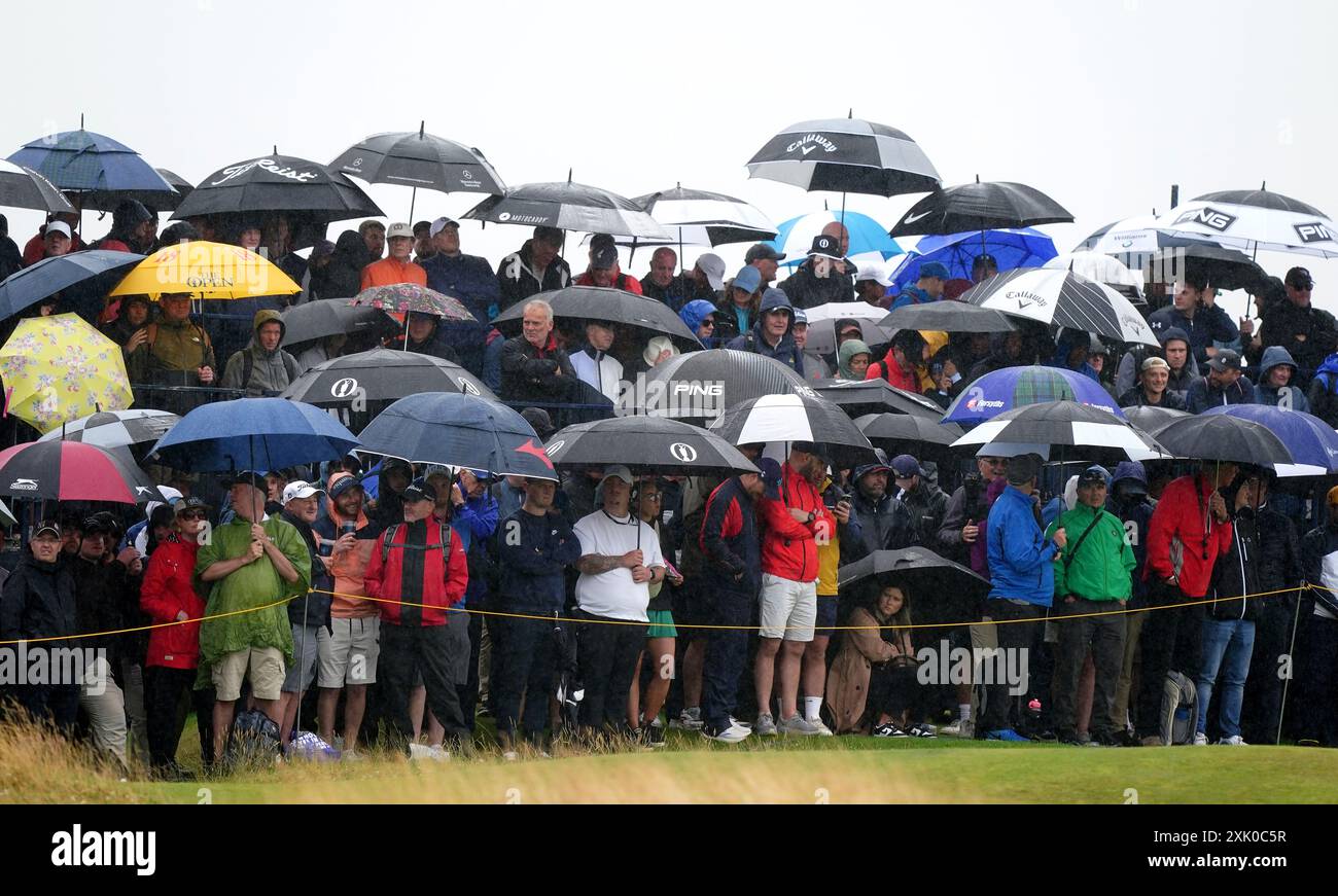 Spettatori sotto ombrelloni durante il terzo giorno dell'Open al Royal Troon, South Ayrshire, Scozia. Data foto: Sabato 20 luglio 2024. Foto Stock