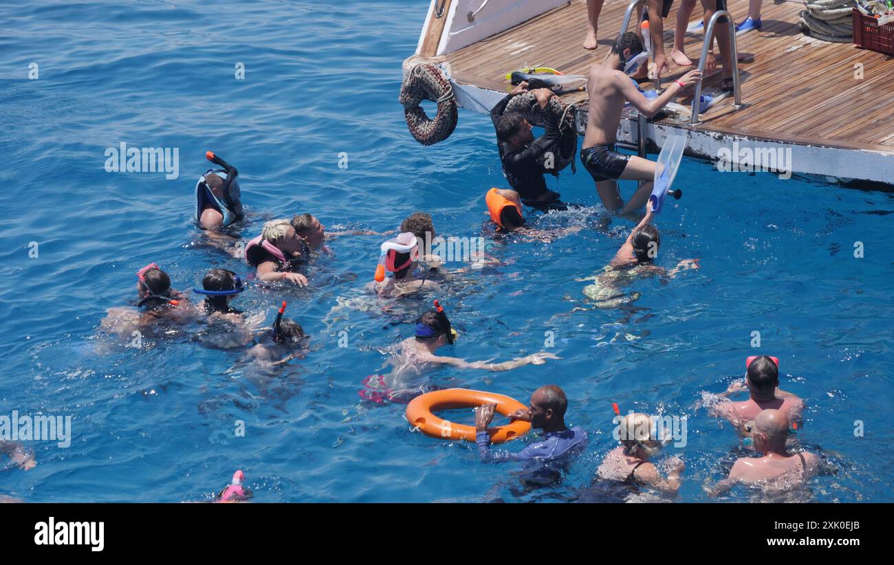 I turisti esplorano la barriera corallina con una gita di snorkeling alla barriera corallina di Gota Abu Ramada, nel Mar Rosso, in una gita di un giorno dal porticciolo di Hurghada Foto Stock