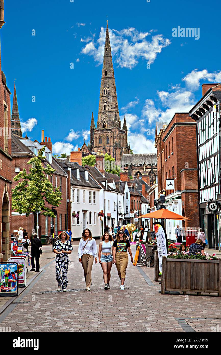 Donne che fanno shopping camminando lungo Dam Street nella città Staffordshire di Lichfield, Inghilterra, con la cattedrale sullo sfondo Foto Stock