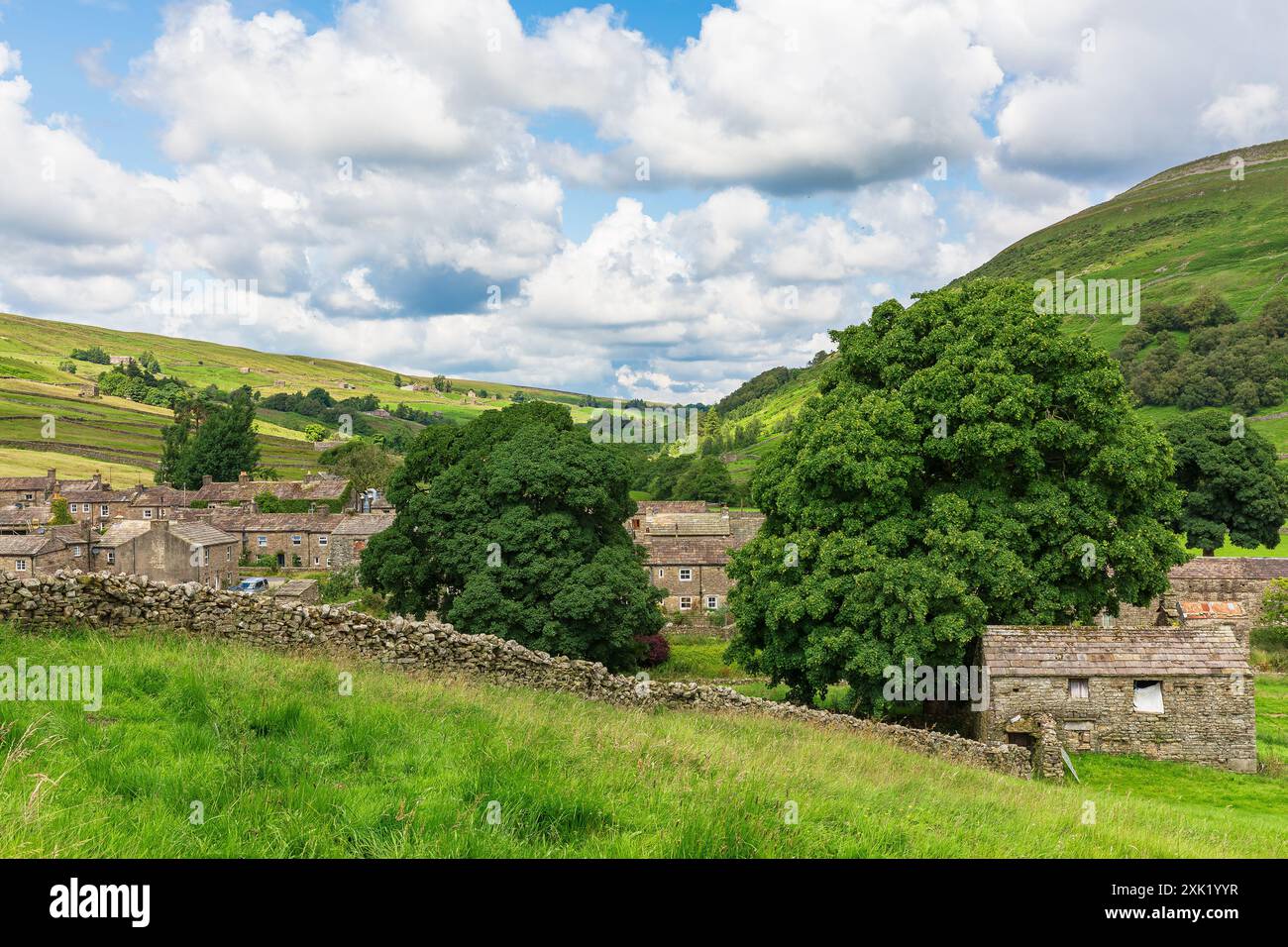 Thwaite, Swaledale, Regno Unito. 24 luglio 2024. Thwaite in estate. Un pittoresco borgo a Swaledale, Yorkshire Dales, Regno Unito, con cottage in pietra e walli a secco Foto Stock