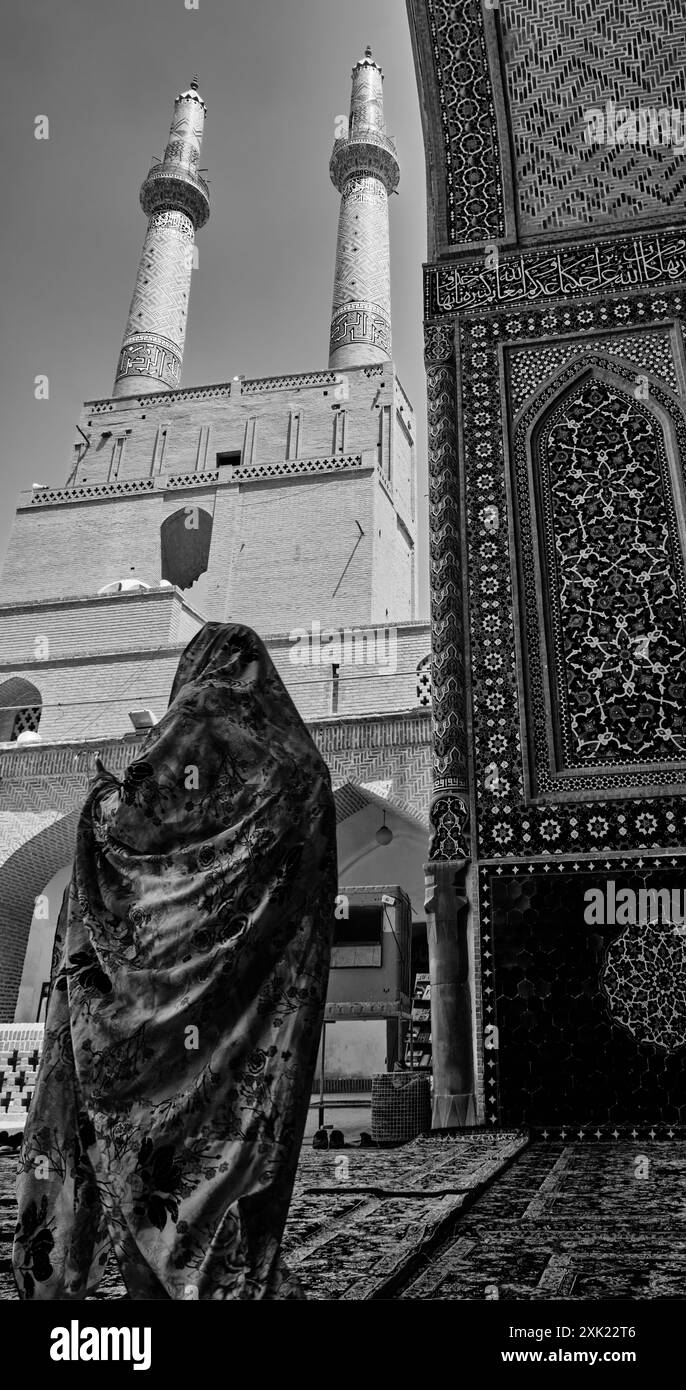 Yazd, Iran, 06.28.2023: Moschea Nasir-ol-Molk, foto in bianco e nero con donna iraniana in burqa. Foto Stock