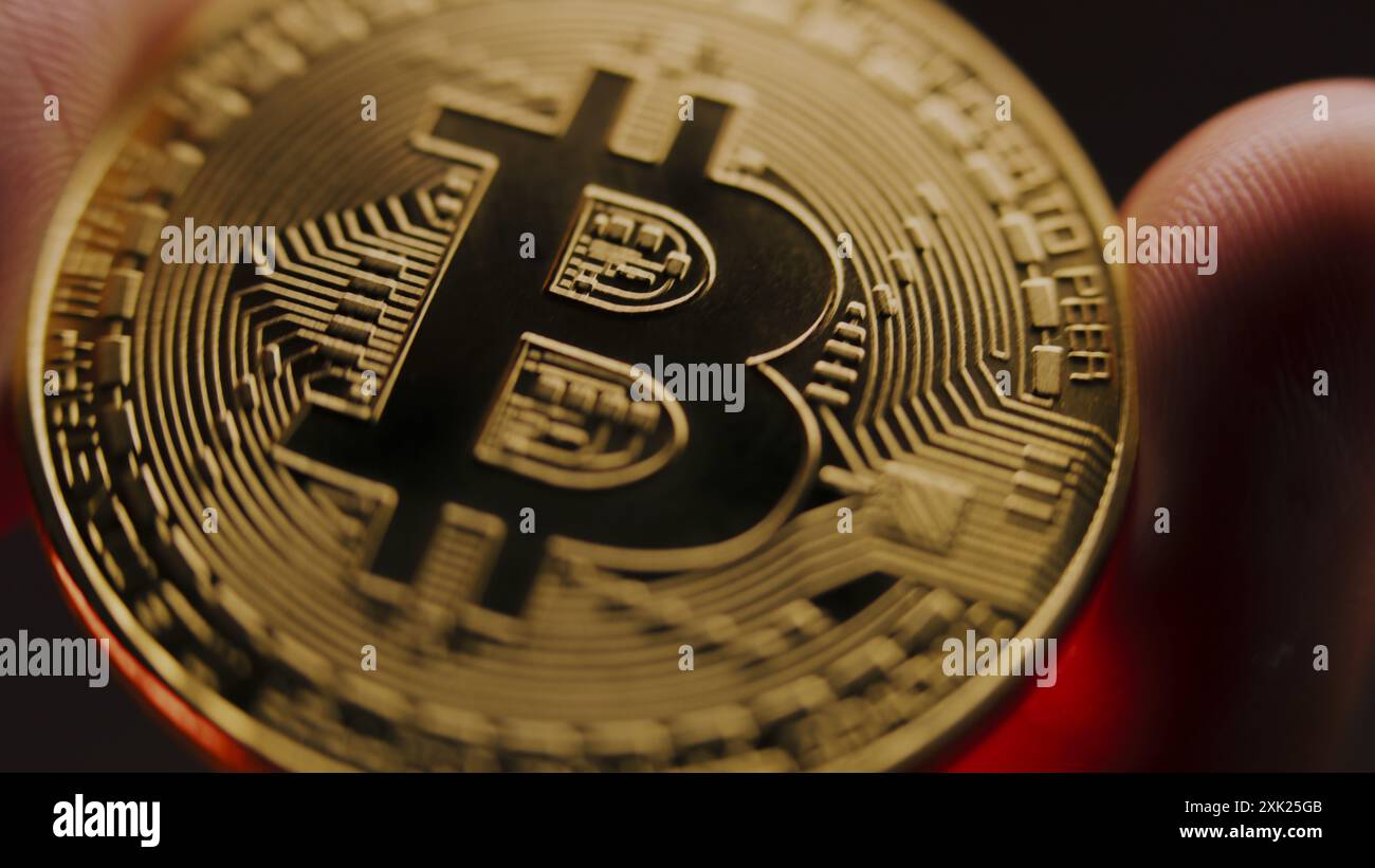 Una persona anonima ha in mano moneta d'oro bitcoin. Criptovaluta elettronica moneta virtuale. Tecnologia moderna Blockchain. Trading di criptovalute P2P bitcoin. Logo BTC. Affari e investimenti. Primo piano. Foto Stock