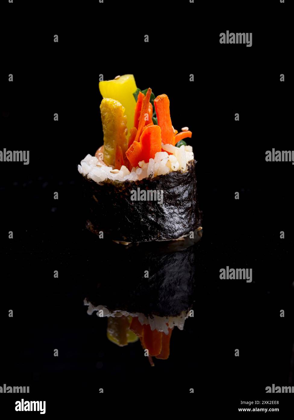 Una foto in studio di una fetta di kimbap coreano che mostra uno specchio come riflesso su uno sfondo nero. Foto Stock