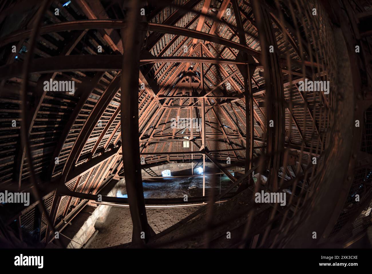 Cattedrale di Saint Pierre struttura attica Ginevra Svizzera // GINEVRA, Svizzera — l'attico della cattedrale di Saint Pierre rivela la sua intricata struttura di supporto in legno e ferro, con un passaggio pedonale che consente l'accesso al campanile. La cattedrale, situata nella città vecchia di Ginevra, presenta una miscela di stili architettonici derivanti dalla sua costruzione che si estende per diversi secoli. La cattedrale di Saint Pierre ha un'importanza storica significativa come la chiesa adottiva di Giovanni Calvino, un leader chiave della riforma protestante nel XVI secolo. Gli elementi strutturali esposti visibili nella demo attico Foto Stock