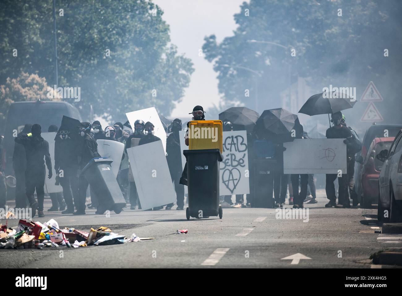 La Rochelle, Francia. 20 luglio 2024, la Rochelle, Francia: I manifestanti prendono posizione contro la polizia in mezzo a gas lacrimogeni con scudi fatti in casa, ombrelli e bidoni della spazzatura per la copertura. Crediti: Jay Kogler/Alamy Live News crediti: Jay Kogler/Alamy Live News Foto Stock