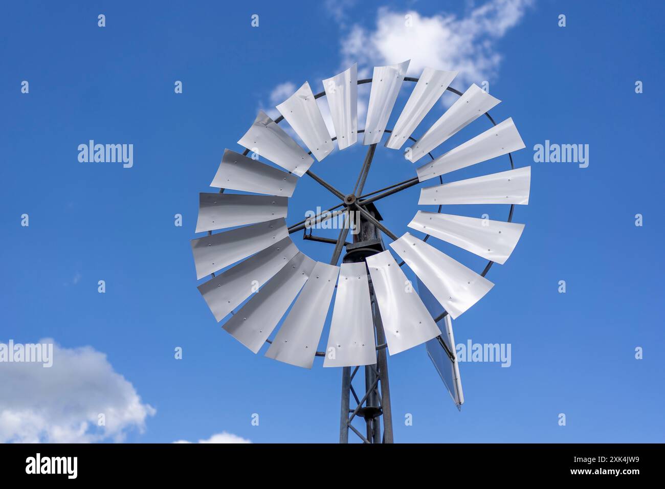 Foto di una mini turbina eolica su uno sfondo di cielo blu con nuvole. Concetto di energia verde a casa Foto Stock