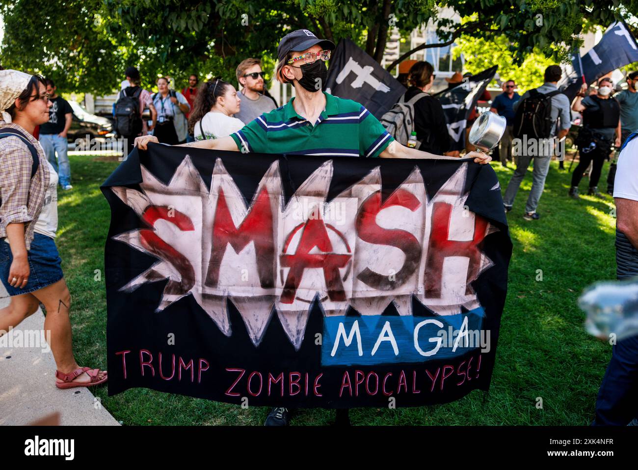 18 luglio 2024, Milwaukee, Wisconsin, Stati Uniti: Una persona detiene una lettura di bandiera, â€œSmash MAGA, Trump Zombie Apocalisse, â€ come arotester marcia e protesta contro la morte di due uomini neri, Samuel Sharpe Jr., per mano della polizia fuori città al RNC, e dÂ€™Vontaye Mitchell, presumibilmente picchiato dai dipendenti dell'hotel, nell'ultimo giorno della Convention Nazionale Repubblicana (RNC), a Milwaukee, Wisconsin. La convenzione proseguì come previsto nonostante il tentativo di assassinio contro Trump e si concluse con lui accettando la nomina presidenziale del suo partito. (Immagine di credito: © Jeremy Hogan/SOPA i Foto Stock