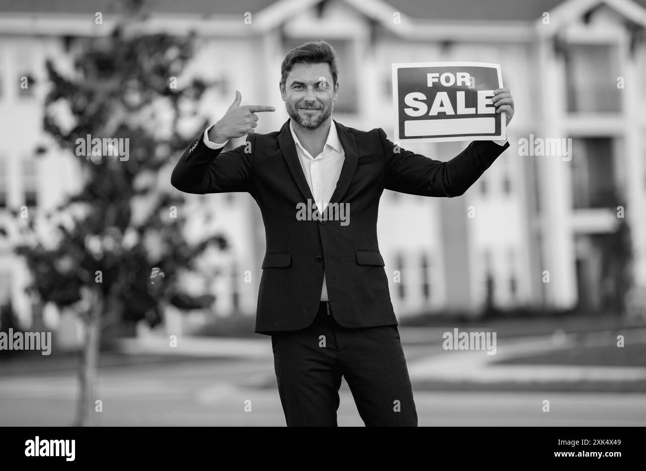 Casa in vendita. Concetto di acquisto e vendita immobiliare. Servizi immobiliari. Uomo d'affari fiducioso in tuta, agente immobiliare, realtor professionale Foto Stock