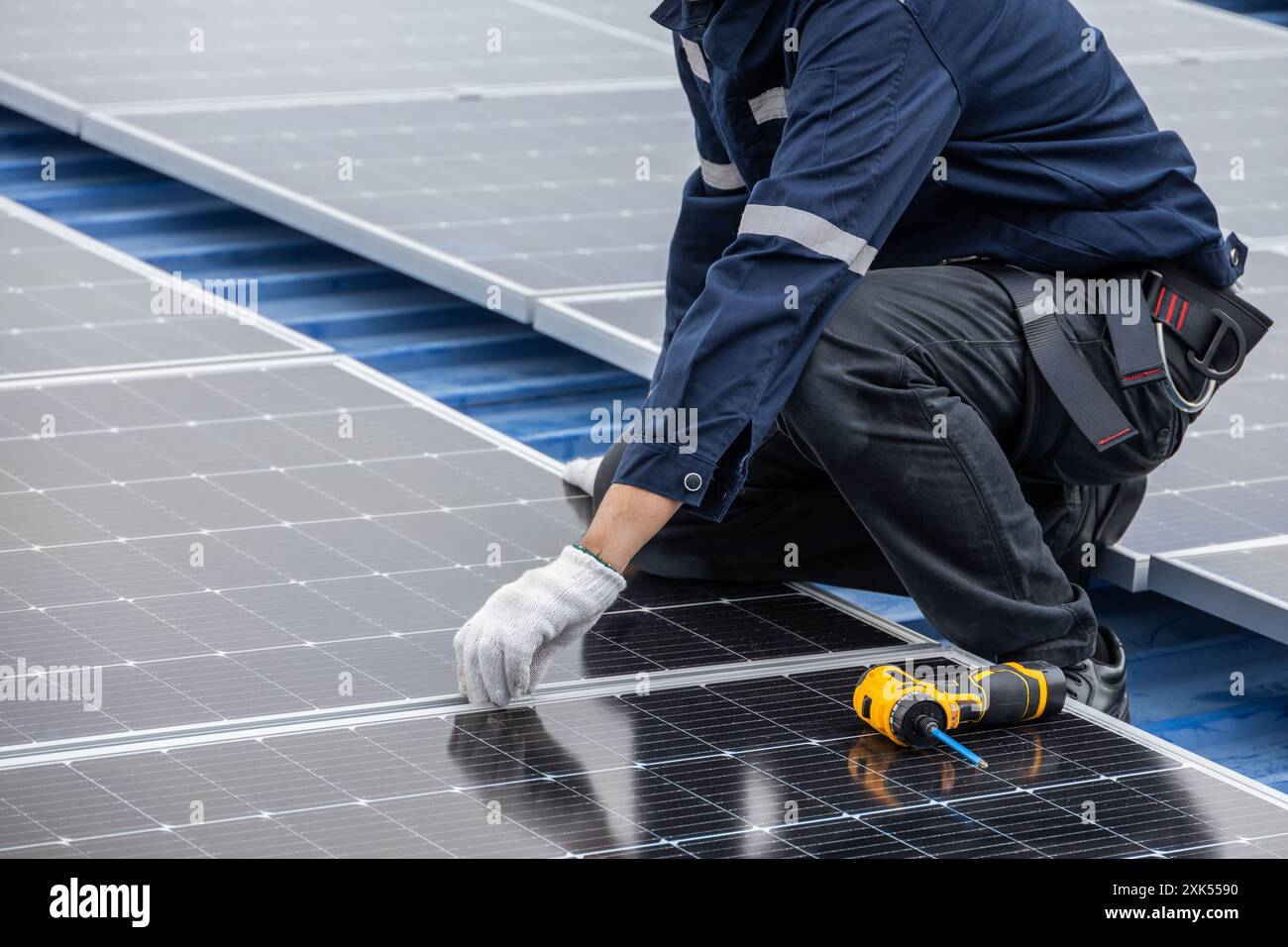 Pannello solare di assistenza tecnico professionale. Manutenzione del lavoratore pulizia sostituzione del pannello solare. Sistema di pannelli fotovoltaici solari in tetto industriale. Salvataggio Foto Stock