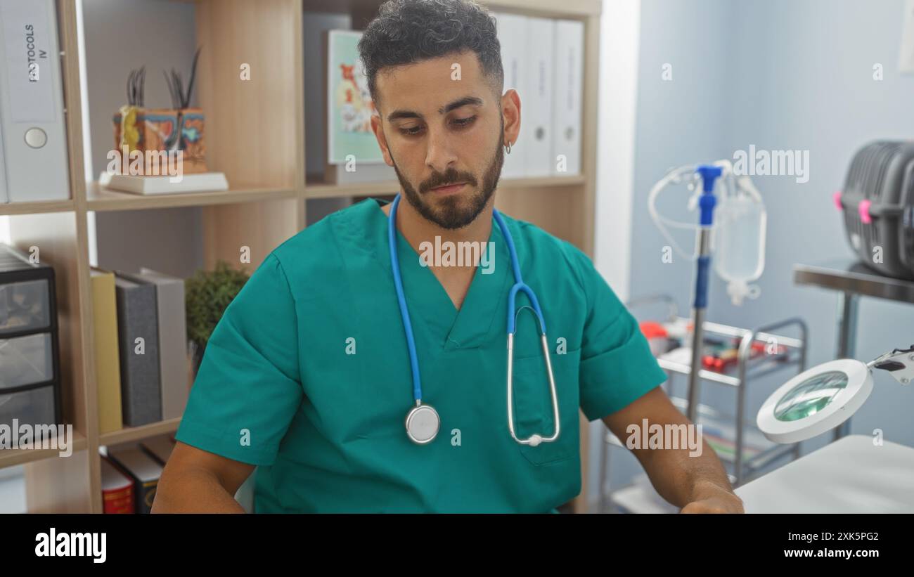 Bell'uomo ispanico in scrub verdi con uno stetoscopio che lavora all'interno di una clinica veterinaria. Foto Stock