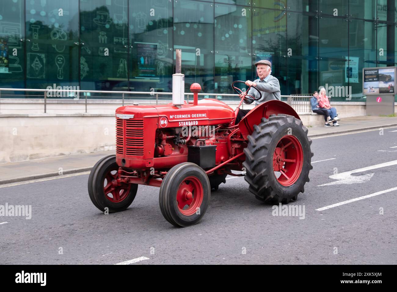 Ballymena, Irlanda del Nord - 19 luglio 2024: Rally trattore d'epoca, Red McCormick Deering Standard passando davanti al municipio in Bridge Street. Foto Stock