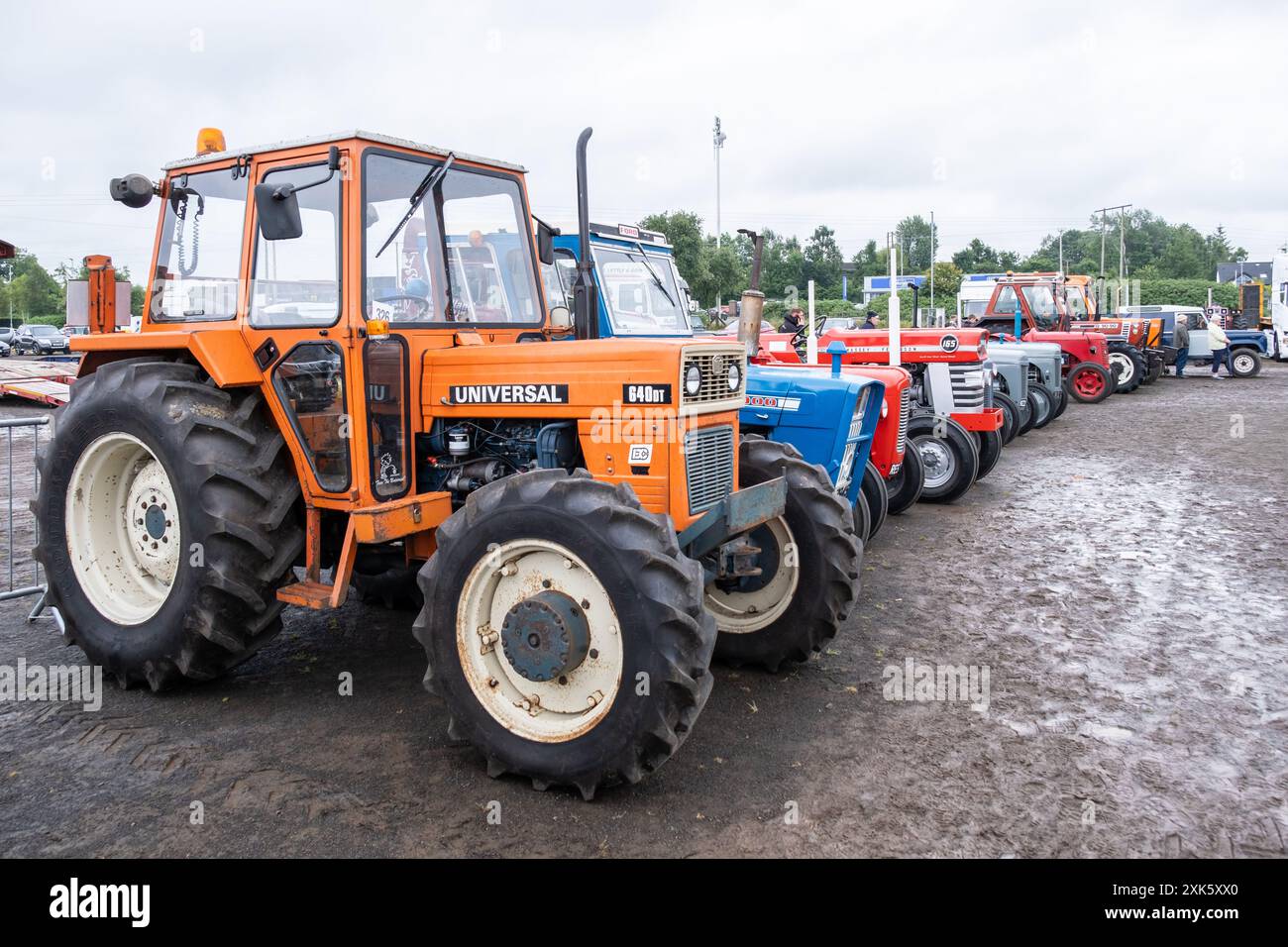 Ballymena, Irlanda del Nord - 20 luglio 2024: Rally di trattori e motori a vapore d'epoca, Universal 640DT arancione davanti alla fila dei veicoli agricoli classici Foto Stock