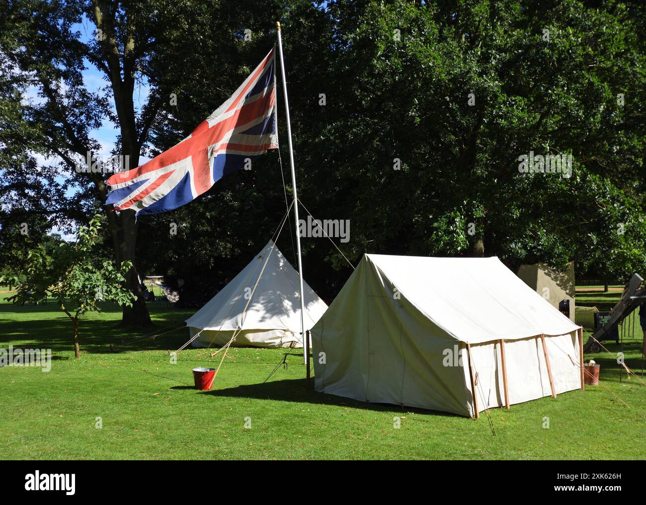 Vecchie tende e bandiera dell'Unione britannica sul palo. Vecchie tende e bandiera dell'Unione britannica sugli alberi di palo sullo sfondo Foto Stock