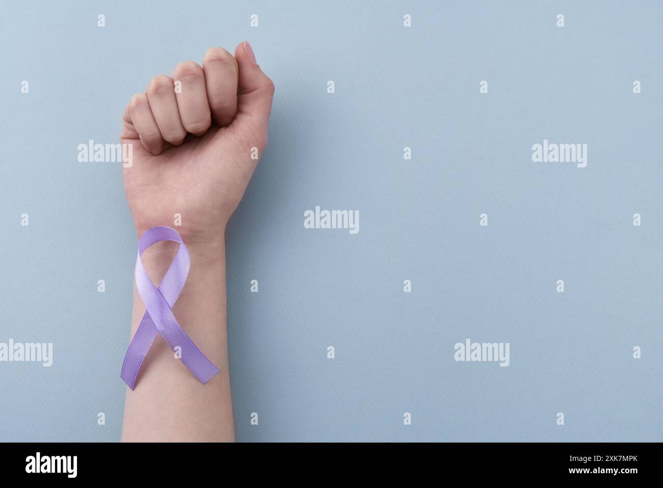 Donna con nastro di sensibilizzazione viola su sfondo azzurro, vista dall'alto. Spazio per il testo Foto Stock