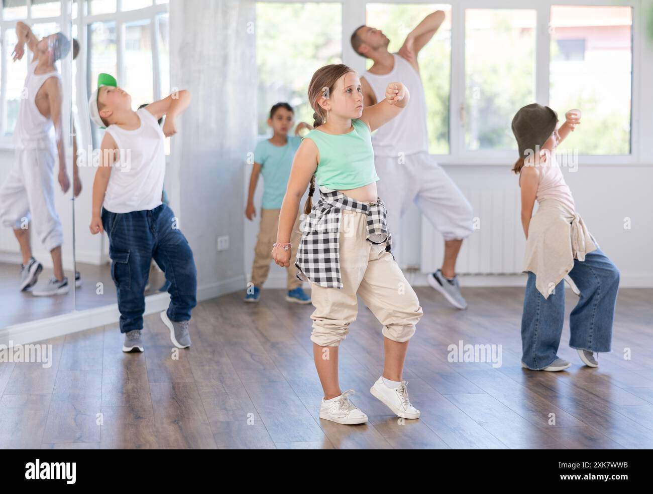 Un gruppo di bambini in abiti casual si sta allenando insieme per ballare hip-hop e breakdance nel centro di danza Foto Stock