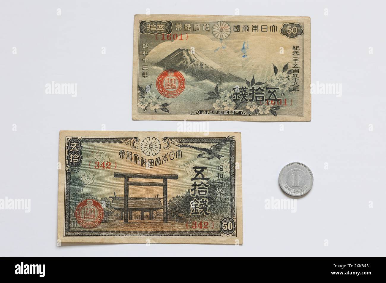 Vecchia valuta giapponese: Due banconote da mezzo senno con una moneta da Yen. Le note mezzo più mezzo seno equivalgono a 1 Yen Flat giapponese su sfondo bianco Foto Stock