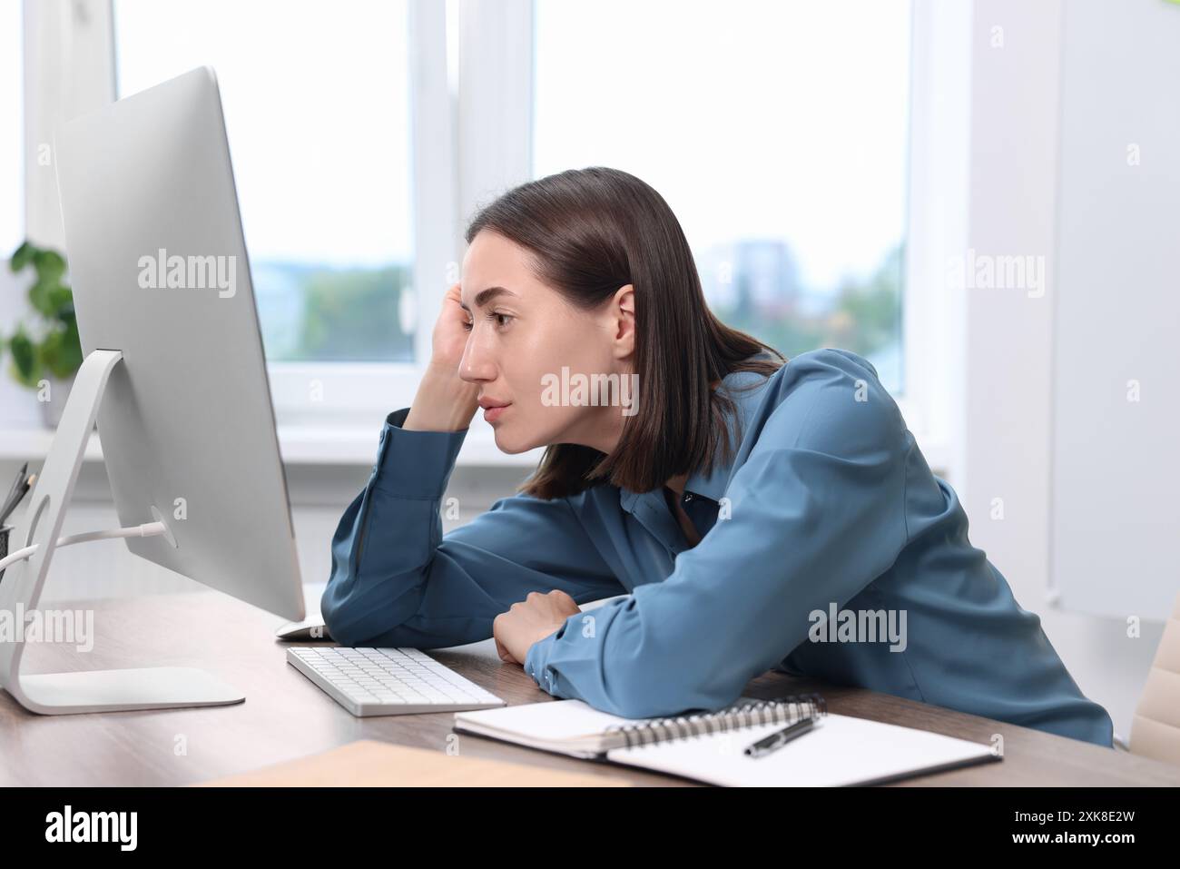 Donna con postura scarsa che lavora in ufficio Foto Stock
