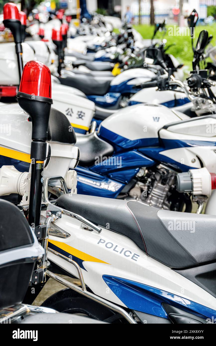 Fila di motociclette della polizia parcheggiate lungo una strada, Shenzhen, Cina Foto Stock