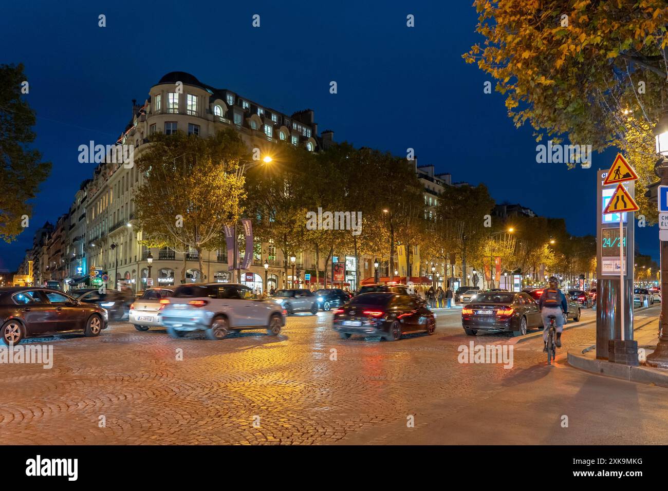 Parigi, Francia - 19 ottobre 2023 : notte a Parigi, Francia, con strade acciottolate e un ciclista che passa accanto alla classica architettura parigina. Foto Stock
