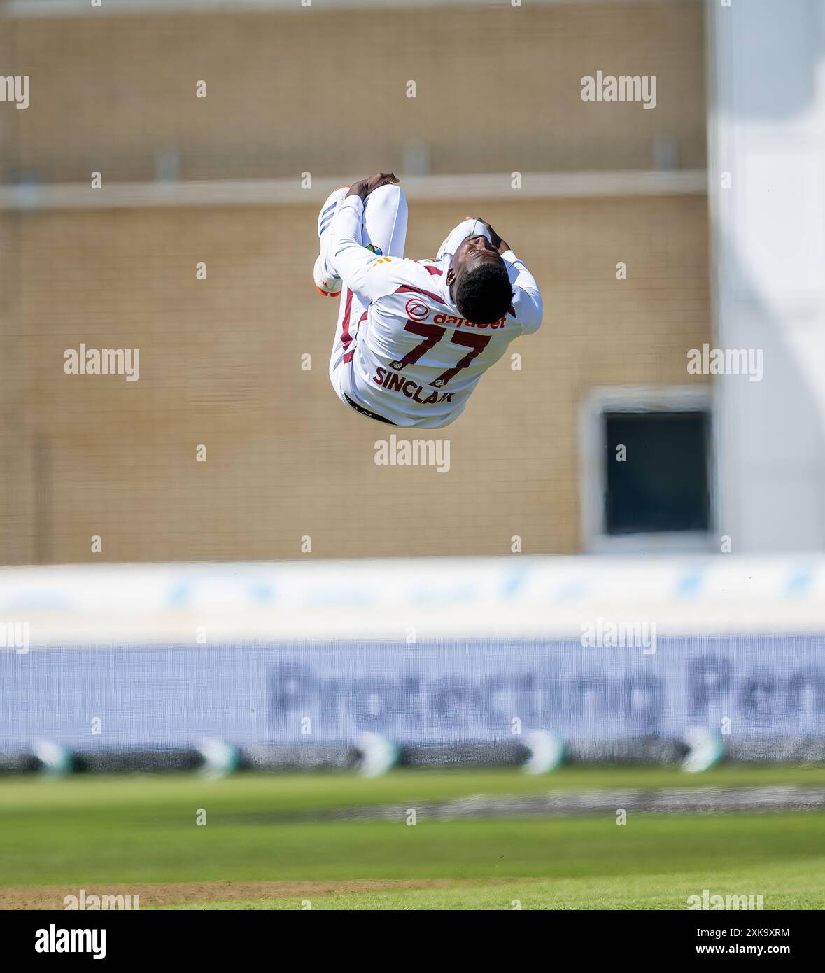 Kevin Sinclair bowling per le Indie occidentali celebra, con un back-flip, il wicket di Harry Brook il primo giorno del secondo test match tra Inghilterra e noi Foto Stock